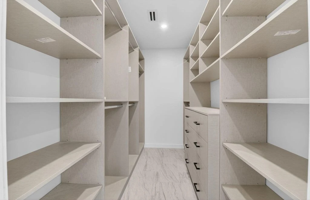 Custom walk-in closet with fitted shelving, drawers and hanging areas in the Boca West renovation