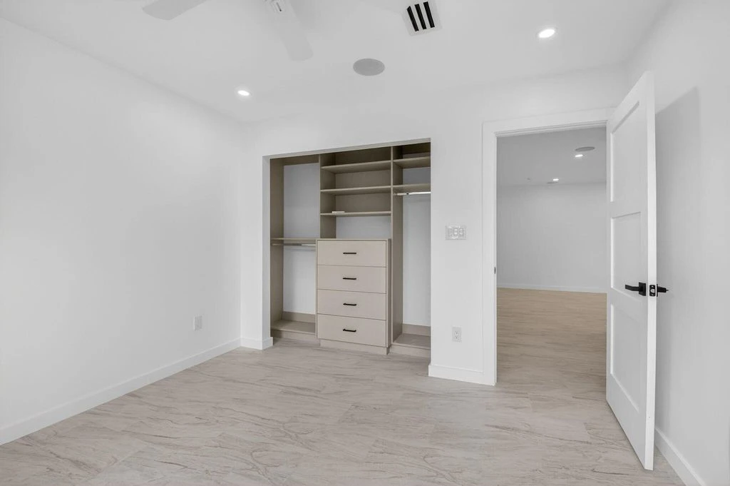 Renovated Boca West bedroom showing fitted closet cabinetry, new flooring and interior doors