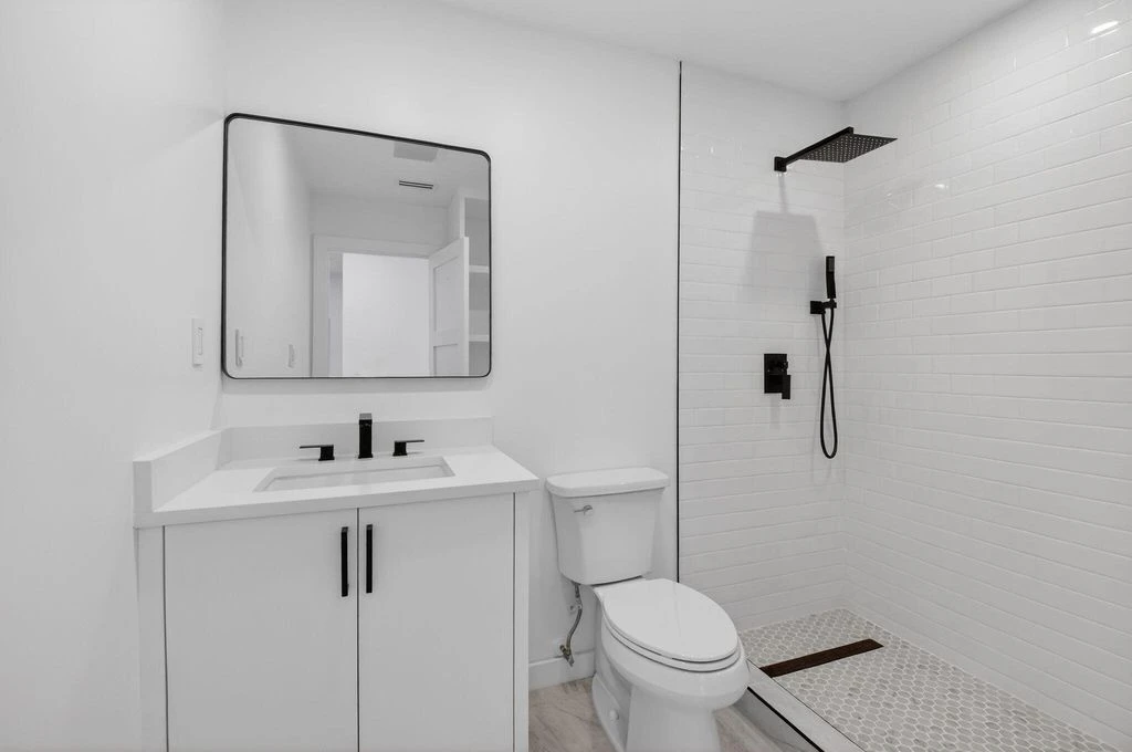 Second renovated Boca West bathroom with custom vanity cabinetry and glass shower