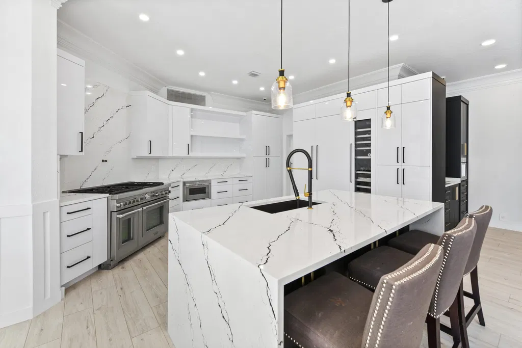 Renovated Woodfield kitchen with a waterfall island, white cabinetry and contrasting dark seating-side cabinetry